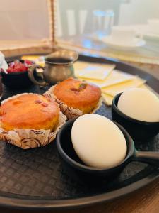 a tray with three cakes and eggs on a table at The Nandi International Boutique Stay in Varanasi