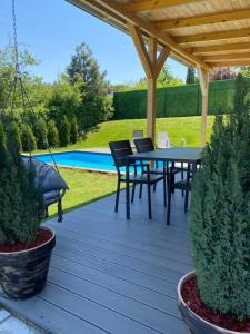 a patio with a table and chairs under a pergola at Woody House with pool in Krčedin