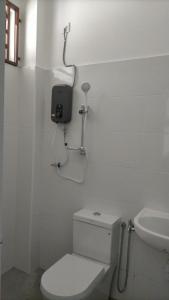 un bagno bianco con un water e un lavandino di Sani Homestay a Malacca
