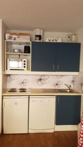une cuisine avec des armoires blanches et un micro-ondes dans l'établissement Appartement 4/6 personnes, au pied des pistes, à Puy-Saint-Vincent 9 autres photos