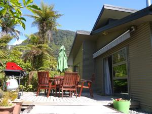弗朗茲約瑟夫的住宿－法蘭士·約瑟夫樹頂度假屋，庭院配有桌椅和遮阳伞。