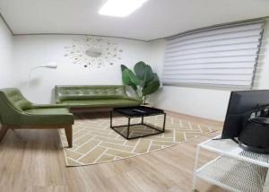 a living room with a green couch and a table at S2 Private Kintex Daehwadong in Goyang