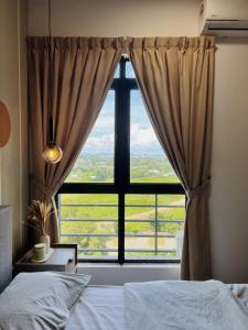 una camera da letto con una grande finestra con vista di K-Avenue by FFix-Stay a Donggongon
