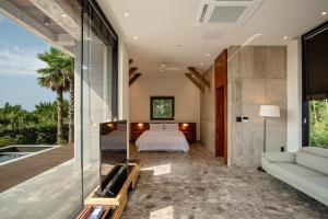 a bedroom with a bed and a glass wall at Ceylon Jeju Pool Villa in Jeju