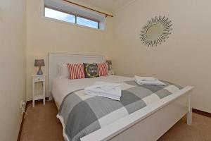 Schlafzimmer mit einem Bett und einem Spiegel an der Wand in der Unterkunft Mr Watson's Cottage near the Battery Point Jetty in Hobart