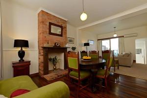 ein Wohnzimmer mit Tisch und Kamin in der Unterkunft Mr Watson's Cottage near the Battery Point Jetty in Hobart