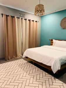 une chambre avec deux lits et un mur bleu dans l'établissement City Retreat Arusha, à Arusha