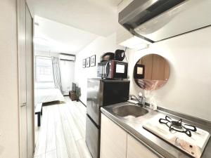 a small kitchen with a sink and a microwave at ティエラ北池袋 in Tokyo +75 photos