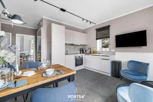 a kitchen and dining room with a table and blue chairs at Ferienwohnung Auftanken St Peter Ording in Sankt Peter-Ording