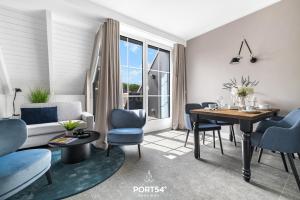 a living room with a table and blue chairs at Ferienwohnung Auftanken St Peter Ording in Sankt Peter-Ording +33 photos