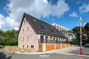 a brick building with a black roof on a street at Ferienwohnung Auftanken St Peter Ording in Sankt Peter-Ording