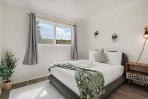 帕西菲卡Charming 2BR 1Bath SofaBed with Mountain Sunset and Ocean Views的一间带床和窗户的白色卧室