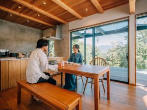 小諸市にある女性のための森サウナ 一棟貸し宿 SORA 宙 Forest sauna villa SORAの台所のテーブルに座る二人