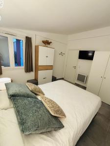 a bedroom with a white bed with two pillows at La Villa Sylody in Lecci