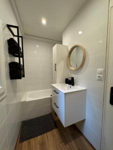 ein weißes Badezimmer mit Waschbecken und Spiegel in der Unterkunft Le POP au 17, appartement cosy dans le centre historique de Rodez in Rodez