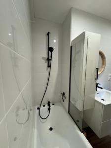 ein weißes Badezimmer mit Dusche und Waschbecken in der Unterkunft Le POP au 17, appartement cosy dans le centre historique de Rodez in Rodez + 7 Fotos