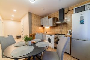 a kitchen with a table and chairs and a refrigerator at Malena Apartments in Šiauliai