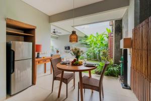 a kitchen and dining room with a table and chairs at Desamuda Village by Pertama Stay in Seminyak