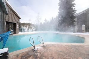 a swimming pool in a yard with snow on it at Iron Horse C5013 condo in Winter Park +36 photos