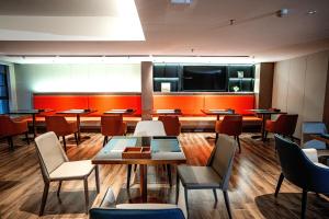 孝感宜尚酒店(孝感东站吾悦广场店)的配有桌椅和平板电视的餐厅