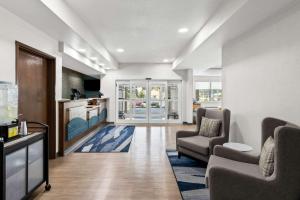 a living room with two chairs and a kitchen at Comfort Inn Schereville in Schererville