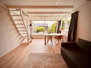 a living room with a table and a large window at Aan de dijk in Dirkshorn