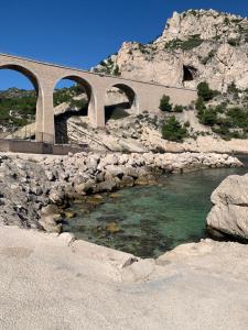 een brug met twee bogen over een rivier met rotsen bij En Plein cœur des calanques à 800 m de la mer in Le Rove