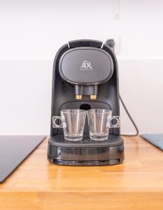 a coffee maker sitting on a table with two glasses at Appartement moderne , trevoux centre historique in Trévoux