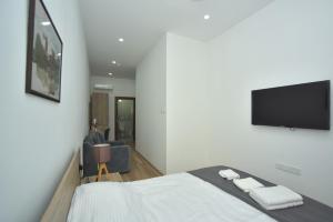 a bedroom with a bed and a flat screen tv at Old Stone Boutique Hotel in Lefkosa Turk