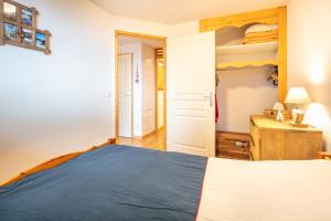 a bedroom with a blue bed and a wooden dresser at Roche et Neige - Proche remontées mécaniques in Chamrousse