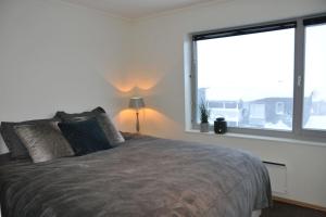 une chambre avec un grand lit avec une grande fenêtre dans l'établissement Leilighet sentralt på Sjusjøen, 11 sengeplasser, à Ringsaker