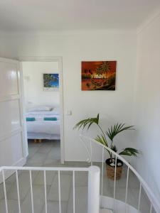 a white room with a potted plant and a bedroom at Bonaire Beach House in Alcudia