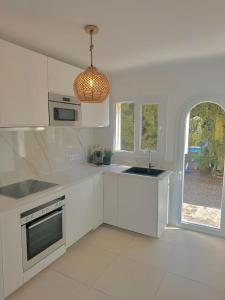 a kitchen with white cabinets and a pendant light at Bonaire Beach House in Alcudia