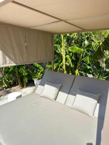 a bed with two pillows sitting under a canopy at Bonaire Beach House in Alcudia