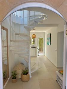 a spiral staircase in a home with an archway at Bonaire Beach House in Alcudia