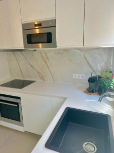 a kitchen with a sink and a microwave at Bonaire Beach House in Alcudia