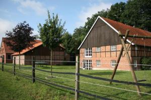 a barn and a fence in front of a building at Landhaus am Esch in Warendorf
