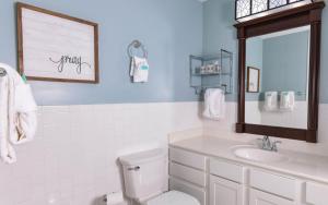 une salle de bain avec toilettes, lavabo et miroir dans l'établissement Red Bud Cottage, à Gatlinburg 13 autres photos