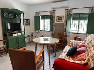 a living room with green cabinets and a table at El Cortijo in Archidona
