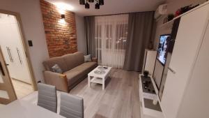 una sala de estar con un sofá y una mesa en Magmares Apartment, en Bydgoszcz