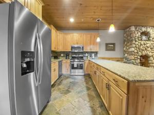 a kitchen with wooden cabinets and a stainless steel refrigerator at 3D Timberwolf Mountain Retreat condo in Park City
