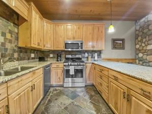a kitchen with wooden cabinets and stainless steel appliances at 3D Timberwolf Mountain Retreat condo in Park City