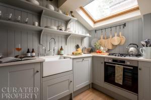 a kitchen with white cabinets and a skylight at Charming Mews House in Historic Winchester in Winchester