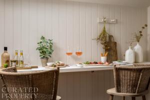 a kitchen with two glasses of wine and two chairs at Charming Mews House in Historic Winchester in Winchester +23 photos