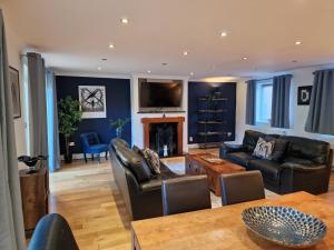 a living room with leather furniture and a fireplace at Large 4-bed house for up to 7 guests w 2x parking in Oxford