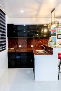 a kitchen with a black counter and a sink at MilGees Vacation House in Cagayan de Oro +5 photos