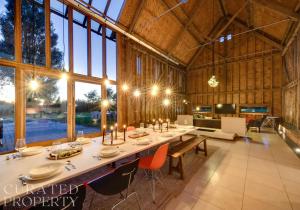 a dining room with a long table in a barn at Grand Suffolk Barn Conversion in Chelsworth