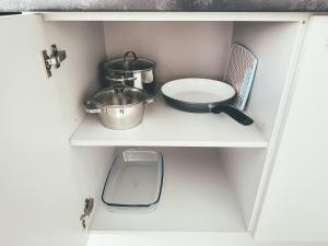 a white cabinet with some pots and pans on it at Cozy Ozo apartments, free parking! in Vilnius +27 photos
