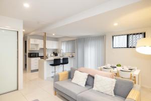 a living room with a couch and a kitchen at Smart Suites Self Check-in Apartments - Sunnybank Station in Brisbane