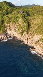 an aerial view of a house on a hill next to the ocean at IZU Elysian View in Koura